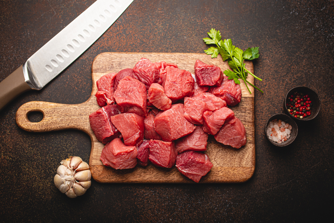 Beef Raw Meat Cubes for Stew on Wooden Cutting Board